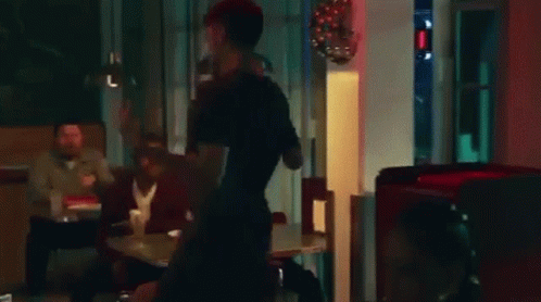 A Man And A Woman Are Fighting In A Restaurant . GIF