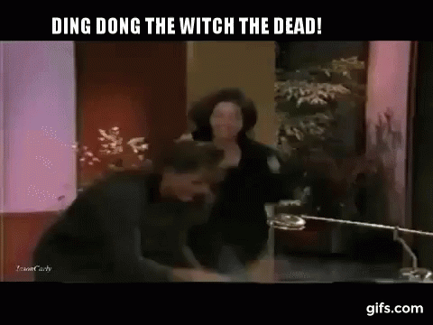 A Man And A Woman Are Fighting In A Room With The Words Ding Dong The Witch The Dead GIF