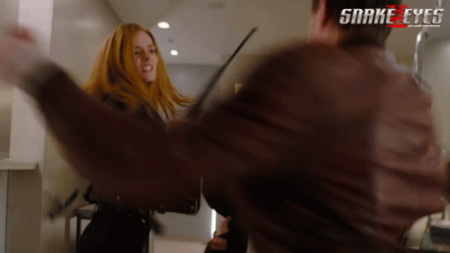 A Man And A Woman Are Fighting In A Scene From Snake Eyes GIF