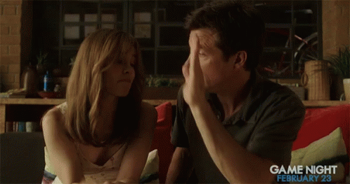 A Man And A Woman Are Giving Each Other A High Five While Sitting On A Couch .. GIF
