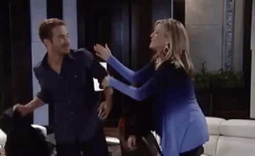 A Man And A Woman Are Having A Fight In A Living Room . GIF