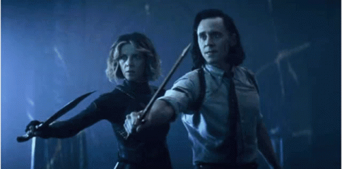 A Man And A Woman Are Holding Knives In A Dark Room . GIF