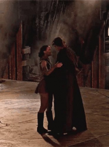 A Man And A Woman Are Hugging And Kissing On The Floor GIF