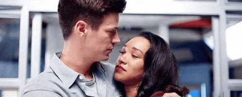 A Man And A Woman Are Hugging Each Other And Looking At Each Other In A Room . GIF