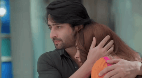 A Man And A Woman Are Hugging Each Other And The Man Is Holding The Woman 'S Head . GIF