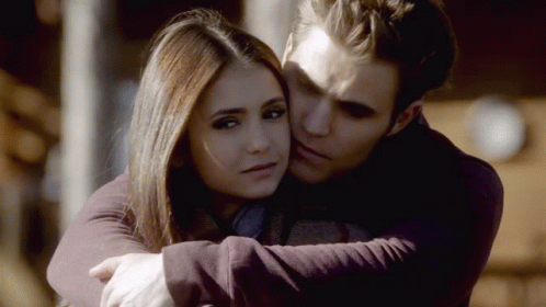 A Man And A Woman Are Hugging Each Other And The Man Is Kissing The Woman On The Forehead GIF