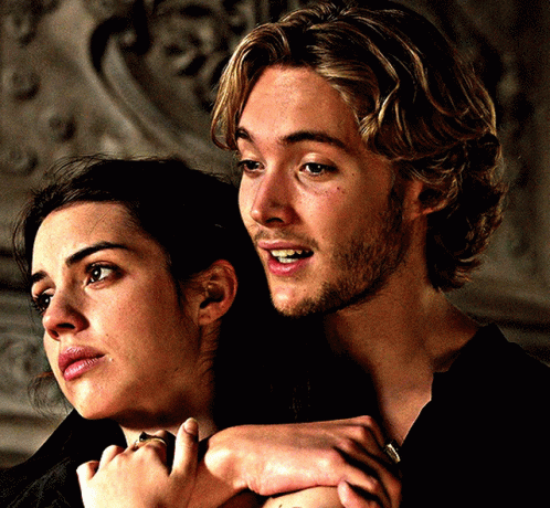 A Man And A Woman Are Hugging Each Other And The Man Is Smiling GIF