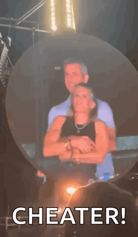 A Man And A Woman Are Hugging Each Other In A Bubble With The Words `` Cheater '' Written On It . GIF