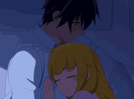 A Man And A Woman Are Hugging Each Other In A Dark Room . GIF