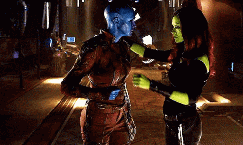 A Man And A Woman Are Hugging Each Other In A Room . The Man Is Wearing A Blue Mask . GIF
