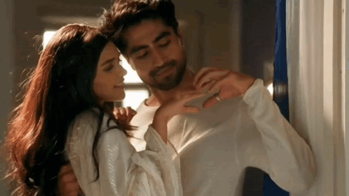 A Man And A Woman Are Hugging Each Other In A Room . The Woman Is Wearing A Wedding Ring . GIF