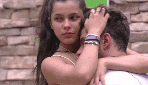 A Man And A Woman Are Hugging Each Other . The Woman Is Touching The Man 'S Forehead . GIF