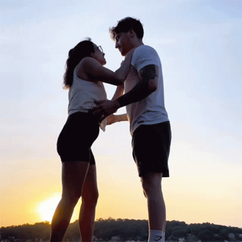 A Man And A Woman Are Hugging Each Other With The Man Wearing A Gymshark Shirt GIF