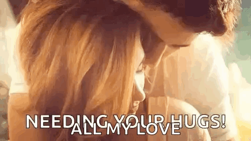 A Man And A Woman Are Hugging Each Other With The Words `` Needing Your Hugs ! '' GIF