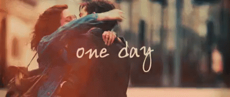 A Man And A Woman Are Hugging Each Other With The Words One Day Written In The Background . GIF