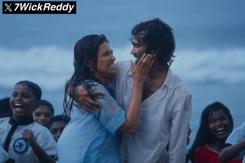 A Man And A Woman Are Hugging On A Beach With X7wick Reddy Written Above Them GIF