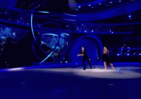 a man and a woman are ice skating on a stage