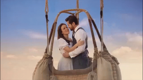A Man And A Woman Are In A Hot Air Balloon . GIF
