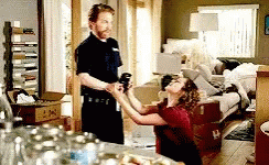 A Man And A Woman Are In A Living Room . GIF
