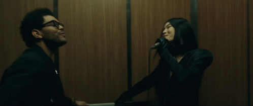 A Man And A Woman Are In An Elevator And The Man Is Smiling GIF