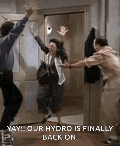 A Man And A Woman Are Jumping In The Air While A Man Holds A Woman 'S Hand . GIF