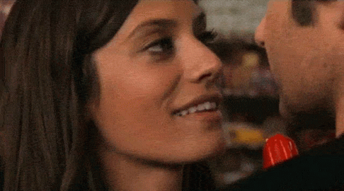 A Man And A Woman Are Kissing And The Woman Is Holding A Lollipop GIF