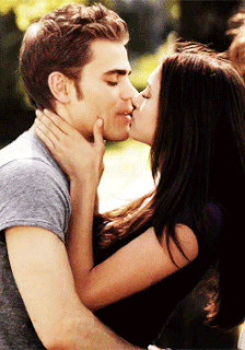 A Man And A Woman Are Kissing And The Woman Is Touching The Man 'S Face GIF