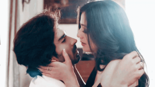 A Man And A Woman Are Kissing And The Woman Is Wearing A Ring On Her Finger GIF