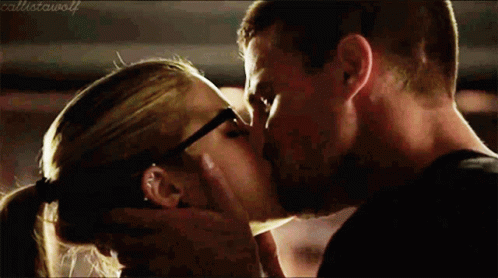 A Man And A Woman Are Kissing And The Woman Is Wearing Glasses GIF