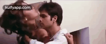 A Man And A Woman Are Kissing Each Other On The Neck . GIF