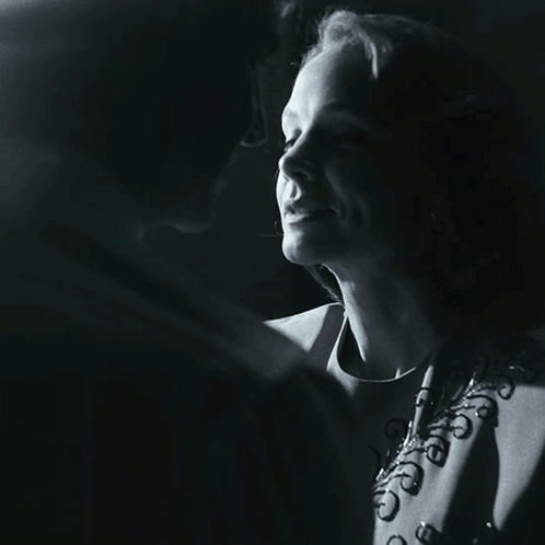 A Man And A Woman Are Kissing In A Black And White Photo GIF