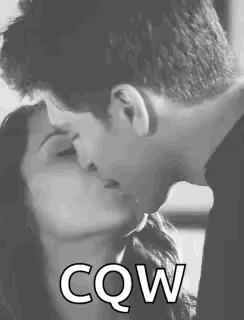 A Man And A Woman Are Kissing In A Black And White Photo With The Words `` Cow '' Written Below Them . GIF