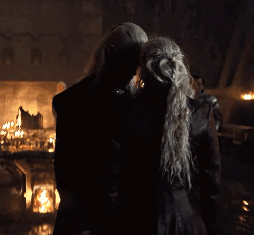 a man and a woman are kissing in a dark room .
