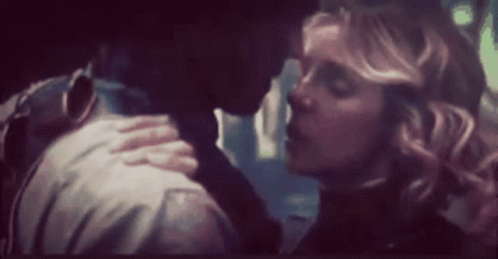 A Man And A Woman Are Kissing In A Dark Room In A Blurry Photo . GIF