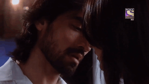 A Man And A Woman Are Kissing In Front Of A Sony Logo GIF