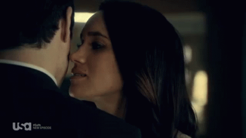 A Man And A Woman Are Kissing In Front Of A Usa Logo GIF
