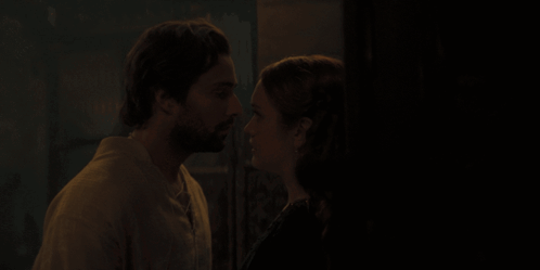 A Man And A Woman Are Kissing In The Dark GIF