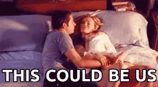 A Man And A Woman Are Kissing On A Bed With The Words `` This Could Be Us '' Above Them . GIF