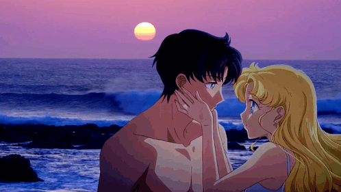 A Man And A Woman Are Kissing On The Beach GIF