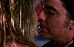 A Man And A Woman Are Kissing With Their Mouths Open . GIF