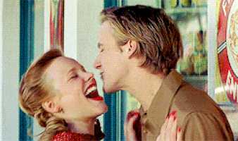 A Man And A Woman Are Laughing And Kissing In Front Of A Vending Machine GIF