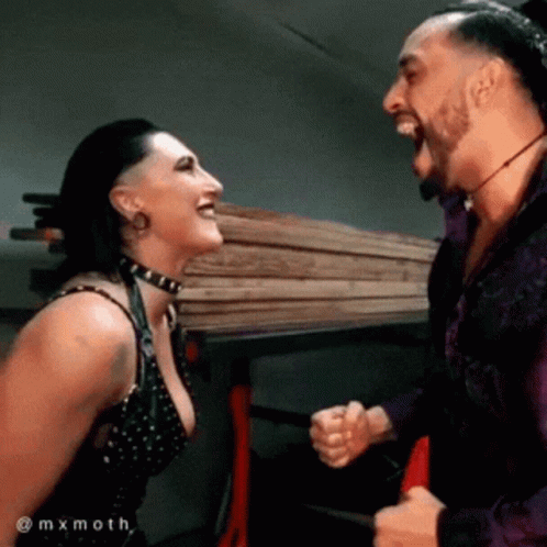 A Man And A Woman Are Laughing At Each Other While Standing Next To Each Other . GIF
