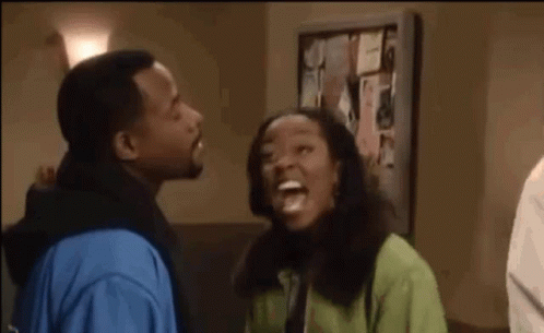 Man And Woman Laughing In Front Of Bulletin Board GIF