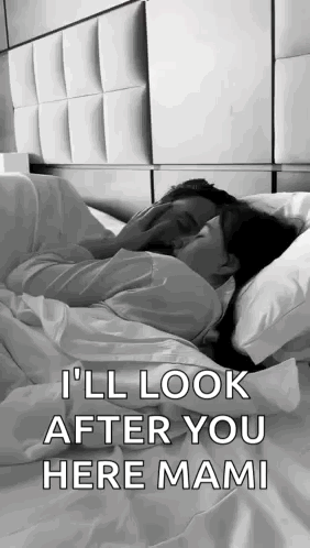 A Man And A Woman Are Laying In Bed Kissing . GIF