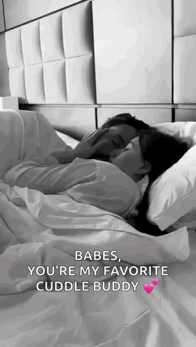 A Man And A Woman Are Laying In Bed Kissing . GIF