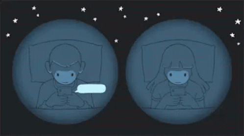 A Man And A Woman Are Laying In Bed Looking At Their Cell Phones GIF