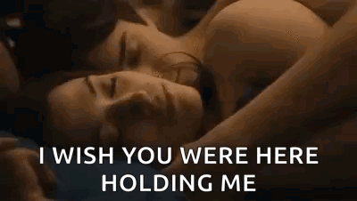 A Man And A Woman Are Laying Next To Each Other In Bed . GIF