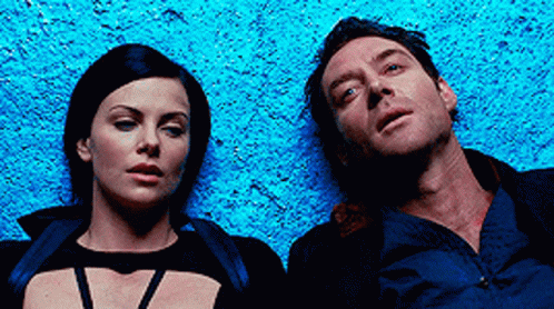 A Man And A Woman Are Laying Next To Each Other On A Blue Surface GIF