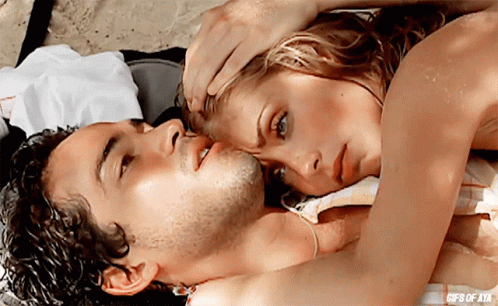a man and a woman are laying on a beach with the words gifs of ata on the bottom right