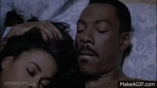 A Man And A Woman Are Laying On A Bed . GIF